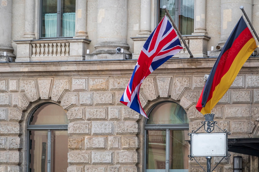 Die Flaggen des Vereinigten Königreichs und Deutschlands hängen an einem Gebäude.